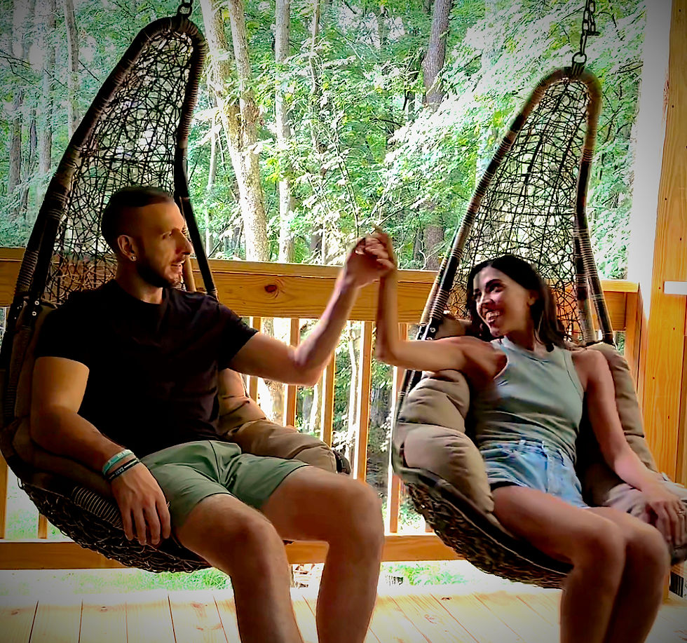 A couple enjoying the swings on the private back deck at GloCabin