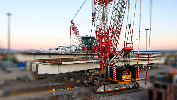 30-Second Takeaway Italian crane specialist Vernazza Autogru has successfully completed two extremely demanding heavy lifts at the Porto di Prà shipyard, installing bridge sections weighing 500 and 290 tonnes using Tadano lattice boom crawler cranes . Operating in a highly congested port environment above active road and rail corridors, the project relied on precise planning, tandem lifting techniques, and the exceptional reliability and maneuverability of Tadano CC crawler cranes—demonstrating the critical role of high-capacity lifting solutions in modern port and shipyard infrastructure. When it comes to lifting and moving particularly heavy loads, the team at Italian crane service provider Vernazza Autogru is especially fond of the powerful lattice boom crawler cranes made by Tadano, no surprise then that this included lifting two bridge sections with a weight of 500 and 290 tonnes for a bridge structure at the Porto di Prà shipyard on behalf of shipbuilding company Fincantieri. The loads consisted of bridge sections built with a composite construction made of steel girders and a concrete deck on top. These sections had to be lifted onto pillars with utmost precision. “These demanding lifts needed cranes that would not just be able to lift extremely heavy loads, but also to move them while suspended in the air. And to tell you the truth, the only candidates qualified for the job were our two Tadano lattice boom crawler cranes,” explains Marco Galli, who was responsible for the project. Before the actual job could be carried out, however, the two cranes had to be transported from Vernazza’s headquarters in Vado Ligure to the work site in Porto di Prà and set up there. Once the machines were at their destination, the crane experts at Vernazza took a mere eight days to set up the CC 68.1250-1 and five to set up the CC 38.650-1. “However, we had to relocate the large CC 68.1250-1 during the work and completely dismantle it in order to rebuild it elsewhere. The assembly-friendly design of the Tadano CC cranes was very helpful, so we were able to master that particular challenge without issue,” reports Marco Galli, who also finds the tremendous reliability and extremely sensitivemaneuverability of Tadano CC lattice boom crawler cranes to be invaluable. Both the reliability and maneuverability proved to be crucial for the job. After all, the lifting work had to be completed within set timeframes at the port’s access area, and this without having any impact on the heavy traffic there other than where absolutely necessary. Specifically, Vernazza had to carry out the lifts at this traffic junction over existing bridges, the Genoa-Ventimiglia railway line and the busy Aurelia state road. The traffic routes were of course to be closed for as short a time as possible - so delays of any kind had to be avoided at all costs. The team planned out every single step in excruciating detail: A tandem lift would be used for the 500-tonne bridge section, while the CC 68.1250-1 would take care of the 290-tonne section all alone. The CC 68.1250-1 was set up with an SSL configuration, a 72-meter boom, and 450 tonnes of Superlift counterweight, while the CC 38.650-1 was also set up with an SSL configuration and a boom of the same length, but 325 tonnes of Superlift counterweight. The two cranes lifted and moved the 500-tonne section together at a radius of 50 meters and a height of seven meters, while the CC 68.1250-1 put the 290-tonne section in place at a radius of 41 meters and a height of nine meters. “We used an eight-person team, consisting of two crane operators and six supervisors and signalpeople, to lift the 500-tonne platform and put it in place with our two cranes. Meanwhile, the team we used to handle the smaller load with the CC 68.1250-1 alone had five people only,” says Marco Galli while explaining how his company’s personnel was deployed for the job. About Vernazza Autogru Vernazza Autogru is a well-established Italian crane and heavy lifting service provider with deep expertise in complex infrastructure, port, shipyard, and industrial lifting operations . Headquartered in Vado Ligure , near one of Italy’s most active port regions, the company operates in environments where precision, coordination, and minimal disruption are critical. Vernazza Autogru specializes in high-capacity crawler and mobile crane operations , including tandem lifts, heavy module installation, bridge construction, and shipyard infrastructure works. The company is known for its detailed lift planning, experienced operators, and strong safety culture, allowing it to perform demanding lifts over live railways, roadways, and port facilities. By maintaining a fleet that includes advanced lattice boom crawler cranes and investing continuously in technical expertise, Vernazza Autogru supports major contractors and industrial clients with tailored lifting solutions that meet strict schedule, safety, and operational constraints, particularly in maritime and coastal environments. Learn More: https://vernazzautogru.com/en/ About Tadano Europe Tadano Europe is the European headquarters and regional operating arm of Tadano Ltd. , a global manufacturer of cranes and lifting solutions. Based in Zweibrücken, Germany , Tadano Europe is responsible for manufacturing, sales, service, engineering support, and parts distribution for Tadano cranes across Europe, the Middle East, and Africa. The company is best known for its lattice boom crawler cranes (CC Series) , as well as all-terrain and rough-terrain cranes engineered for heavy lift, infrastructure, industrial, energy, and maritime applications. Tadano Europe’s crawler cranes are widely deployed in ports, shipyards, power plants, offshore support operations, and major civil engineering projects , where reliability, precision, and uptime are critical. Tadano Europe places strong emphasis on engineering support and lifecycle services , providing customers with technical planning assistance, crane configuration expertise, operator training, and long-term parts availability. This comprehensive approach ensures Tadano cranes perform efficiently throughout their service life, even in the most demanding heavy lift environments. 🔗 Learn more: https://www.tadano.com/europe Frequently Asked Questions What was lifted at the Porto di Prà shipyard? Two bridge sections weighing 500 tonnes and 290 tonnes, constructed from steel girders with a concrete deck, were lifted and positioned onto bridge pillars. Who was the end client for the project? The lifting operations were carried out on behalf of Fincantieri , a global shipbuilding company. Which cranes were used for the lifts? Vernazza Autogru used two Tadano lattice boom crawler cranes : a CC 68.1250-1 and a CC 38.650-1 . How were the lifts executed? A tandem lift was used for the 500-tonne bridge section, while the 290-tonne section was lifted by the CC 68.1250-1 alone. Both cranes were equipped with Superlift configurations. Why was this project particularly challenging? The lifts took place above existing bridges, the Genoa–Ventimiglia railway line, and the Aurelia state road, requiring extremely precise execution and minimal disruption to heavy traffic flows. How long did crane assembly take? The CC 68.1250-1 was assembled in eight days, while the CC 38.650-1 took five days. The larger crane was also fully dismantled and rebuilt at another location during the project. What made Tadano crawler cranes suitable for this job? Their high lifting capacity, precision maneuverability, reliability, and assembly-friendly design made them the only viable option for moving extremely heavy loads while suspended.