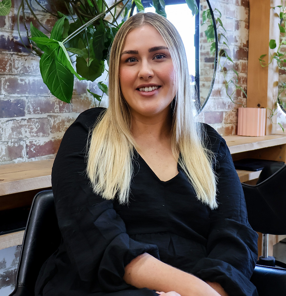 Blonde woman smiling at Evernew Hair Studio.