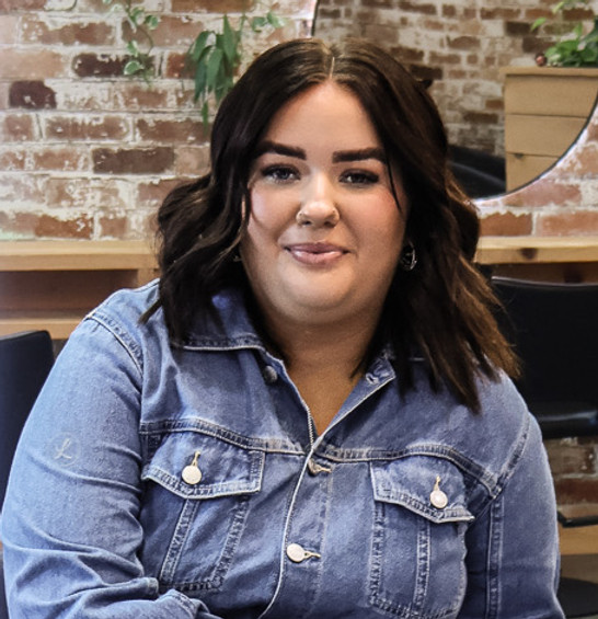 Woman smiling in a mirror at Evernew Hair Studio