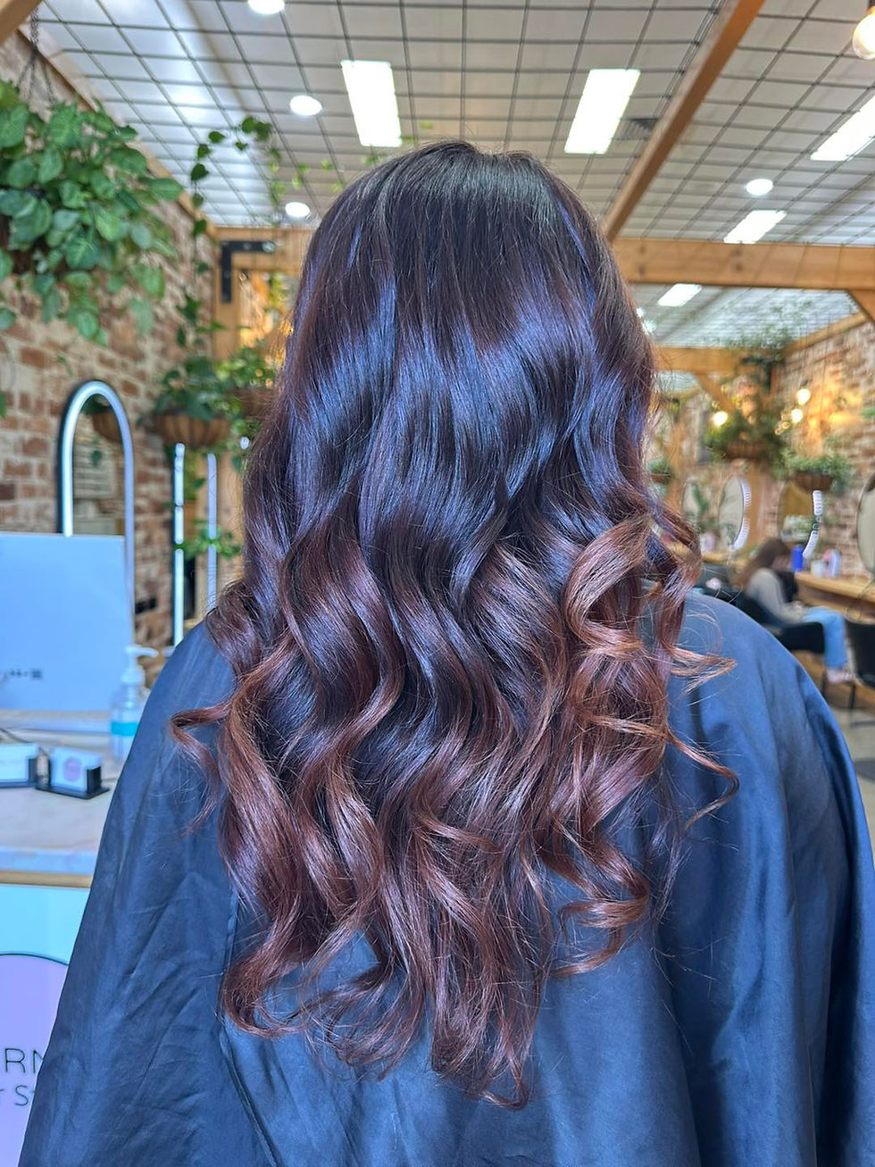 Woman with styled, dark brown hair at Evernew Hair Studio