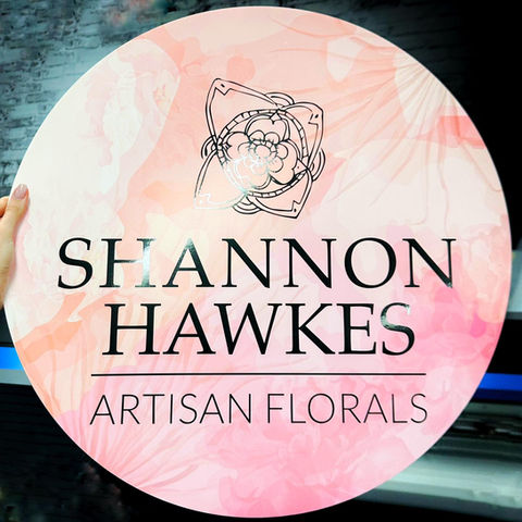 A round acrylic sign for Shannon Hawkes Artisan Florals.