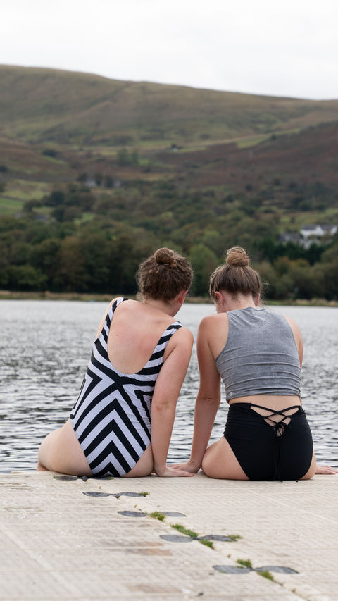 women sitting at lake