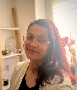 Frau die vor einem Fenster sitzt