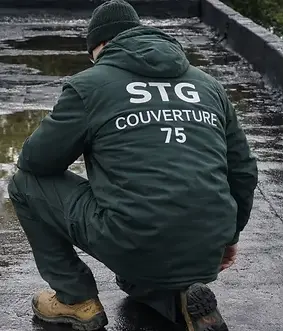 Couvreur STG Couverture 75 inspectant l’étanchéité d’un toit-terrasse dans le 19ᵉ arrondissement de Paris