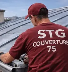 Couvreur zingueur STG Couverture 75 réalisant des travaux de zinguerie sur une toiture en zinc dans le 19ᵉ arrondissement de Paris