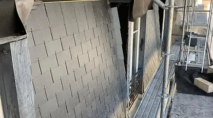 Rénovation d’un brisis de toiture en ardoises naturelles sur un immeuble parisien avec échafaudage lors d’un chantier de couverture réalisé par des couvreurs