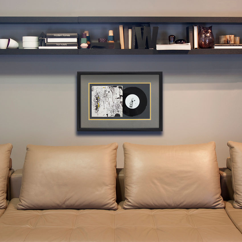 a framed picture of a record on a wall above a couch
