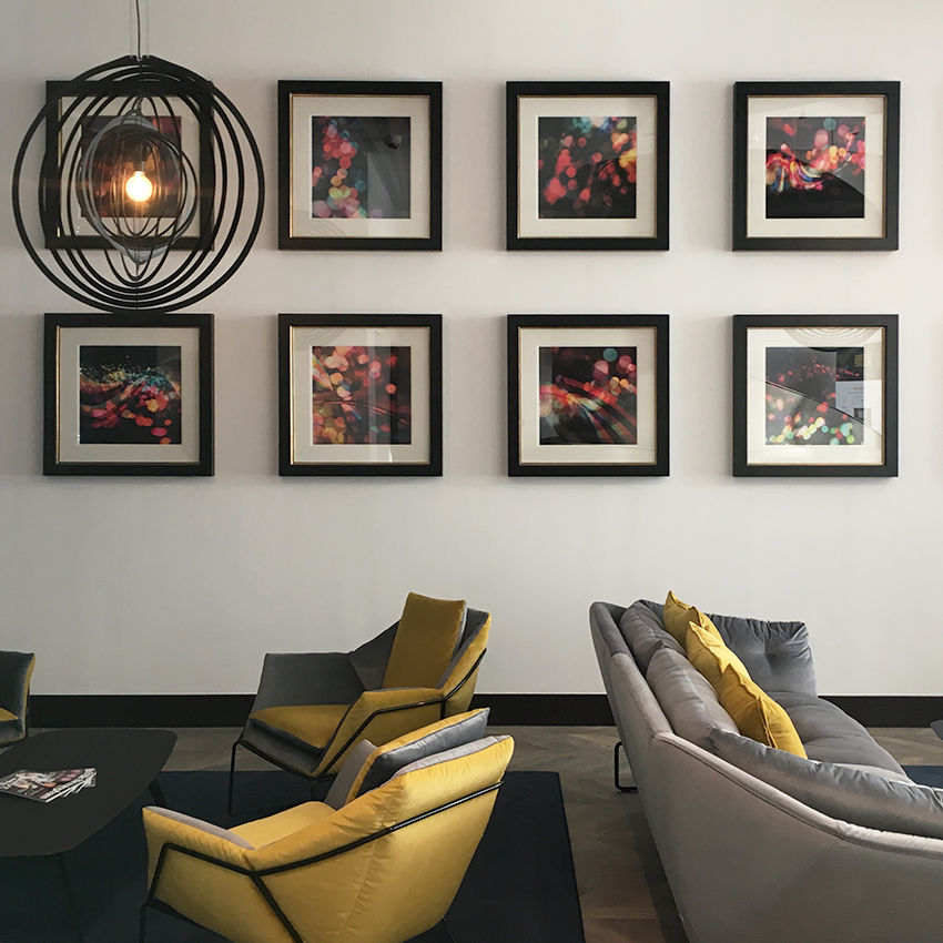 a living room with a couch and chairs and paintings on the wall