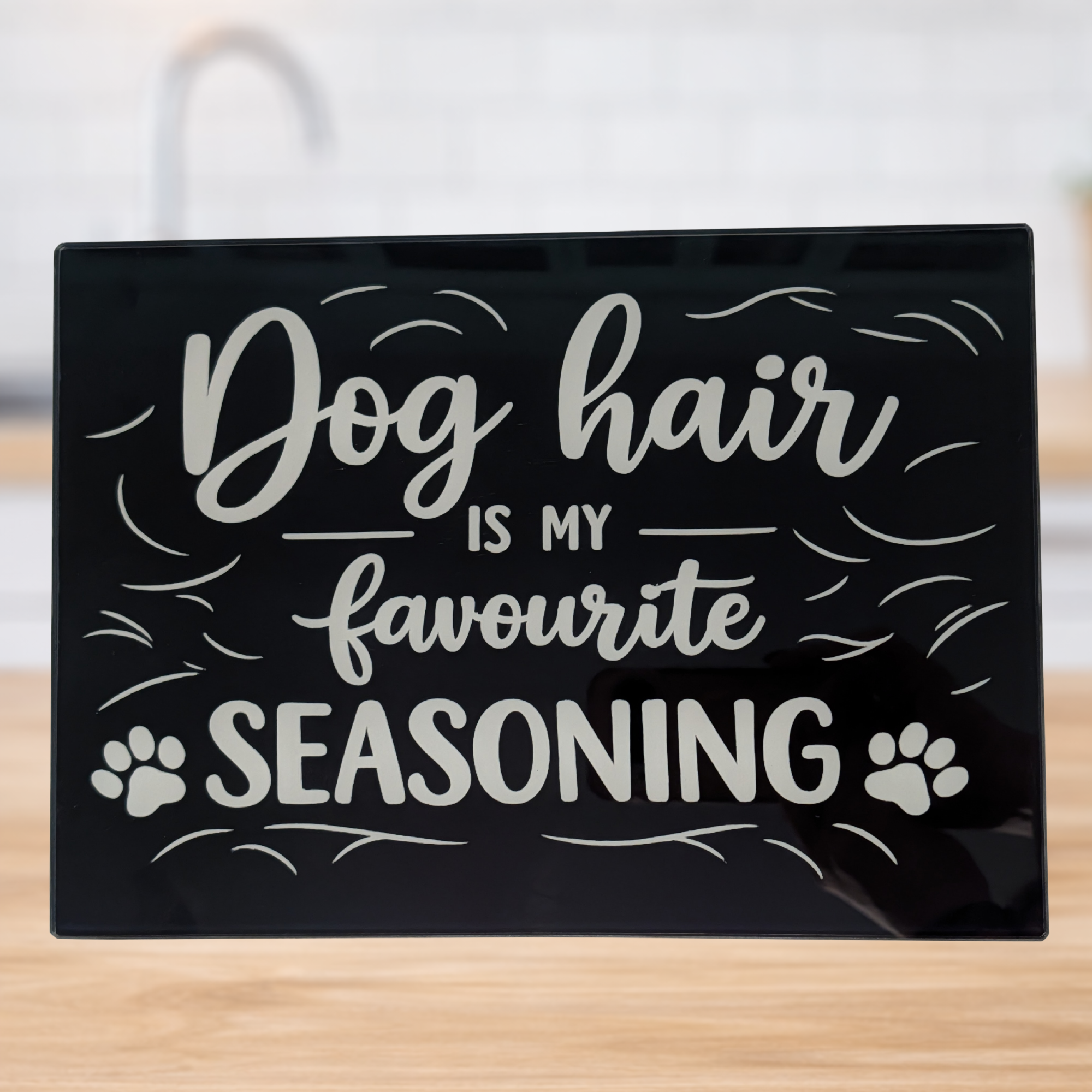 Dog hair is my favourite seasoning glass chopping board with white text and black background in modern kitchen