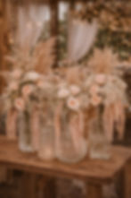 Vases with pink roses, baby's breath, and pampas grass