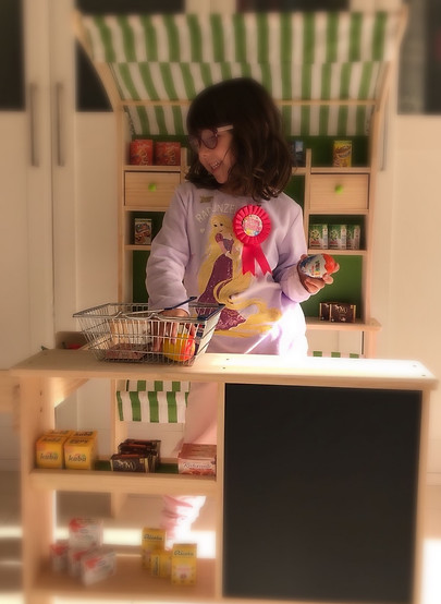 niña jugando en la cocina de juguete