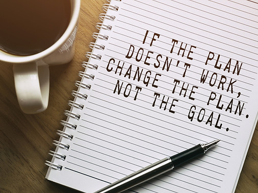 The phrase "If the plan doesn't work, change the plan. Not the goal." is written on a notebook