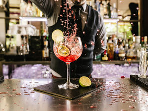 A bartender pouring a colorful cocktail into a glass at a modern bar, symbolizing the U.S. nightlife industry’s focus on craft drinks, experience, and profitability.