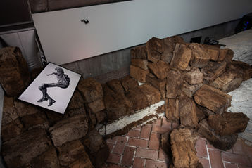 Animation still of a translucent human-like shape on screen placed on peat blocks.