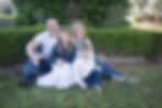 The Baker family of four siting outside on the grass.