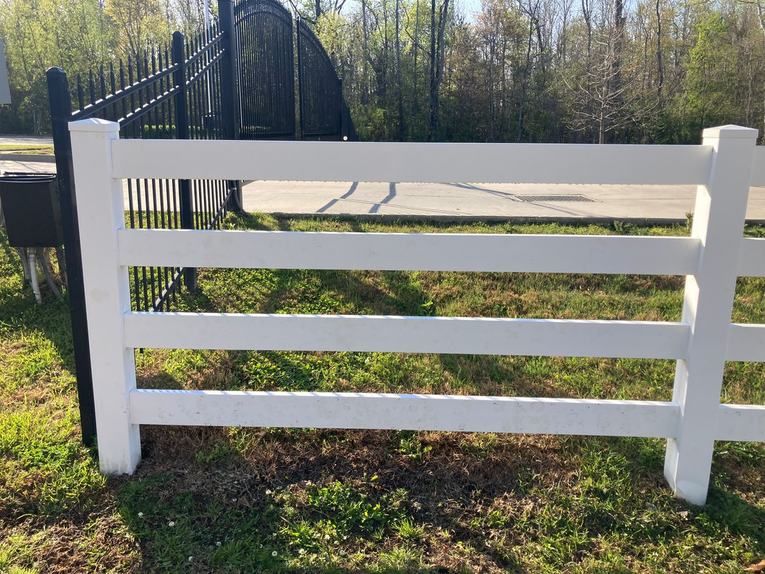 White three-rail fence after pressure washing