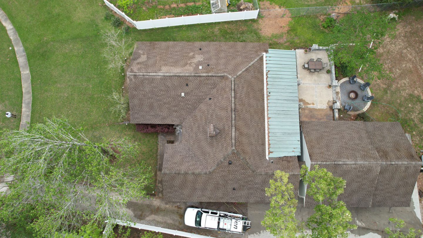 Aerial view of house roof, showing asphalt shingles and patio