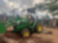 Person operating green tractor at playground