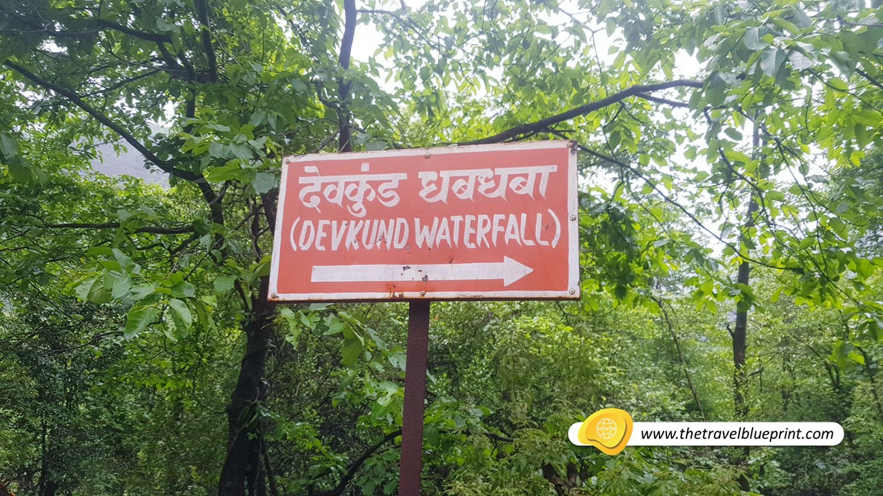 Devkund Waterfall direction sign with a arrow and a sign on it