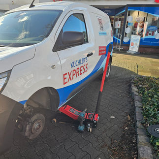 „Eine mobile Reifenreparatur direkt vor einer Apotheke, schnelle Hilfe unterwegs.“