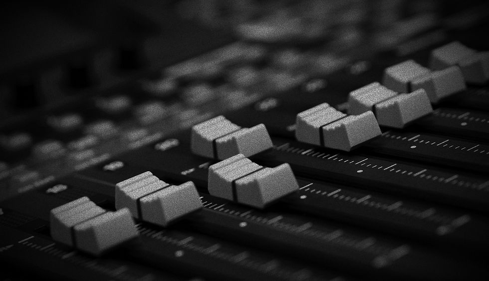 Nahaufnahme eines Audiomischpults mit Reglern und Knöpfen im CROSSFADE AUDIO Studio.