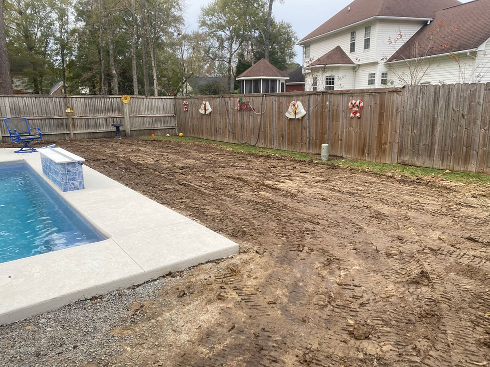 Dirt area cleared for new landscaping projects by a pool.