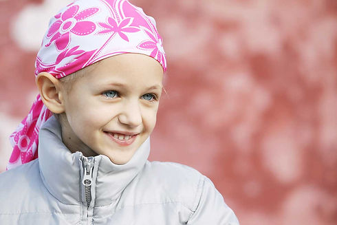 A young girl, cancer survivor, with pink headband and winter jacket.