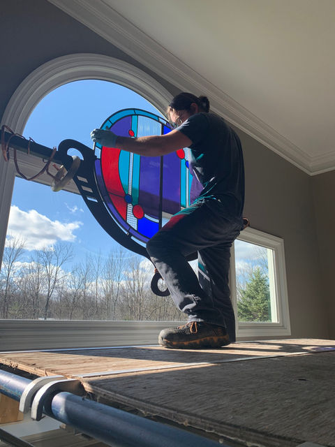 The installation of the custom framed stained glass window
