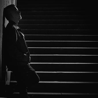 Gustav Müller leaning against a wall in front of stairs