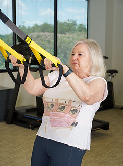 Patient conducting back rehabilitation exercise during physical therapy in Houston.