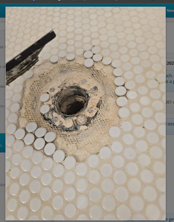 Close-up of a bathroom sink drainage pipe beneath a sink faucet in a single bathroom stall. Focus on plumbing and fixture details.