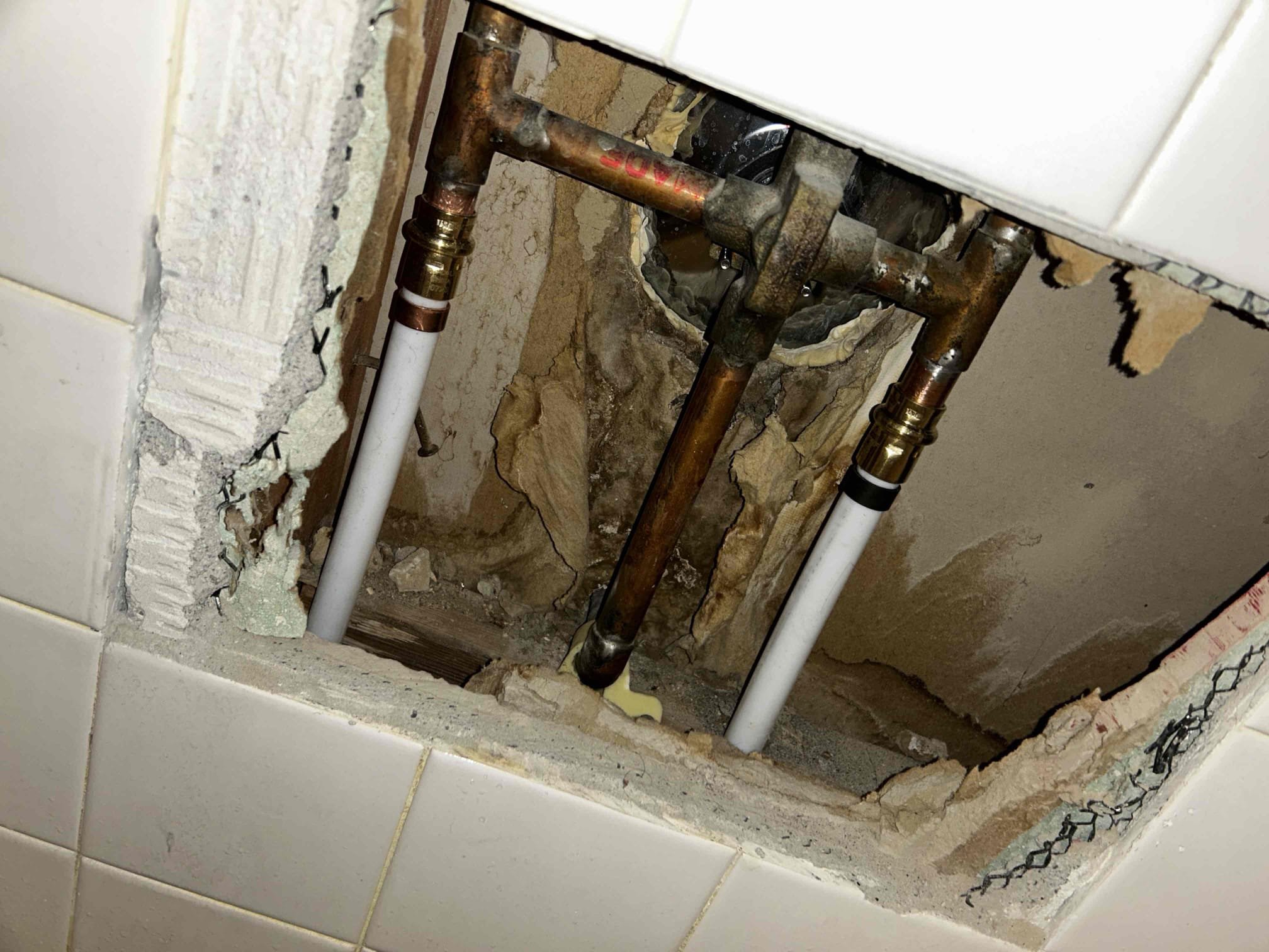 Image depicts a water softener system installed in a home to combat hard water issues, often identified through online well water testing. Addressing hard water can prevent potential problems like residential ceiling water damage, which may require professional restoration services.