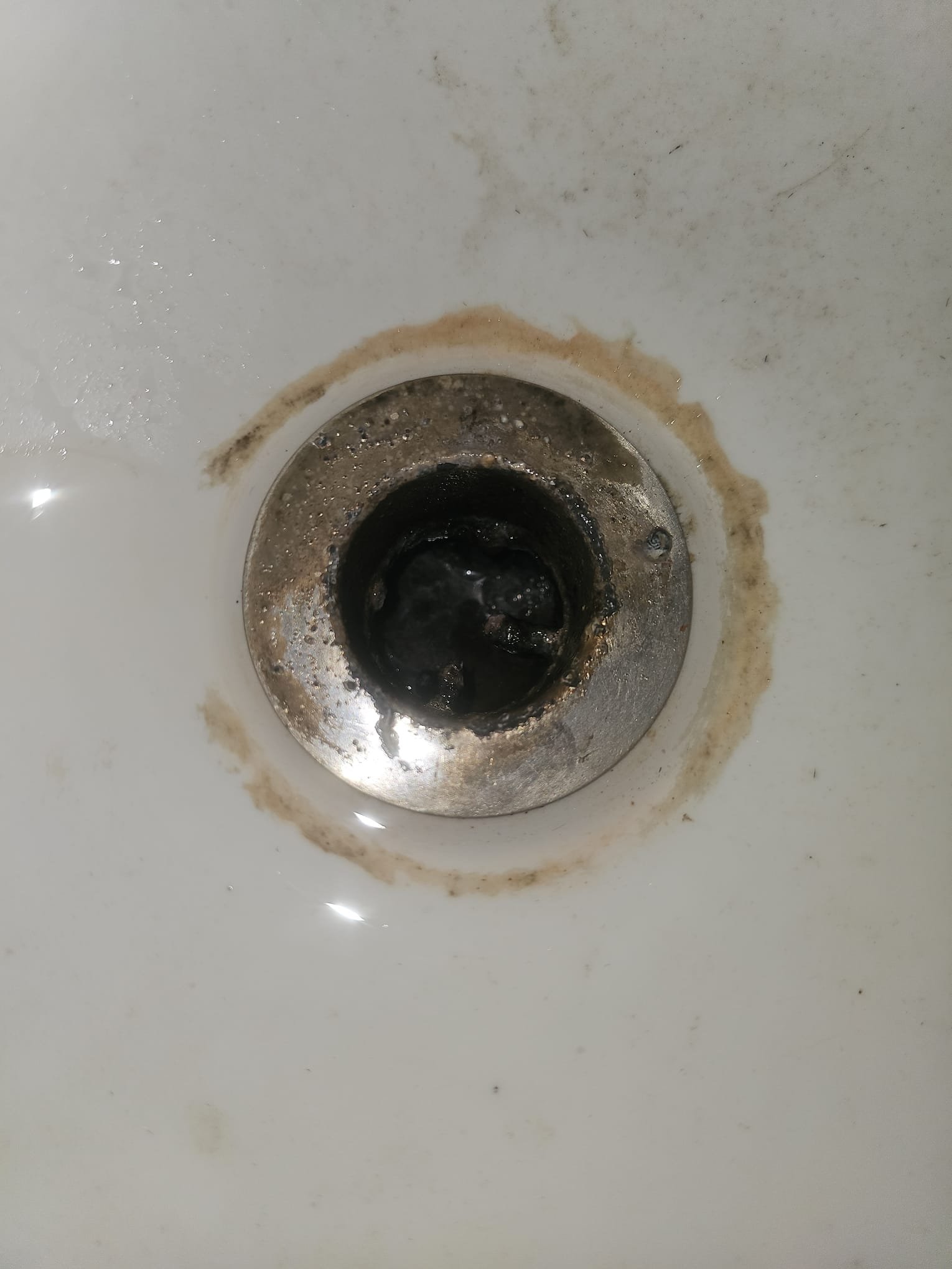 Image depicting drain cleaning services. A plumber uses a drain snake auger to clear a clogged drain, highlighting local 'drain cleaning near me' solutions for fast and effective plumbing maintenance.