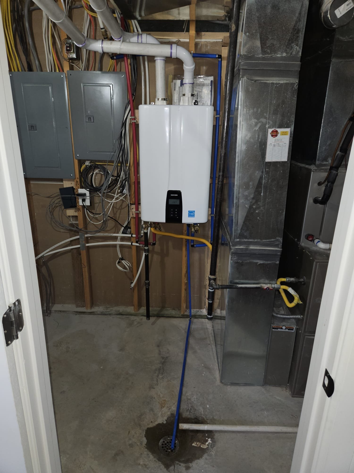 Image about the cost of hot water heaters, specifically electric models. A leaking water heater is shown, emphasizing potential repair or replacement expenses.