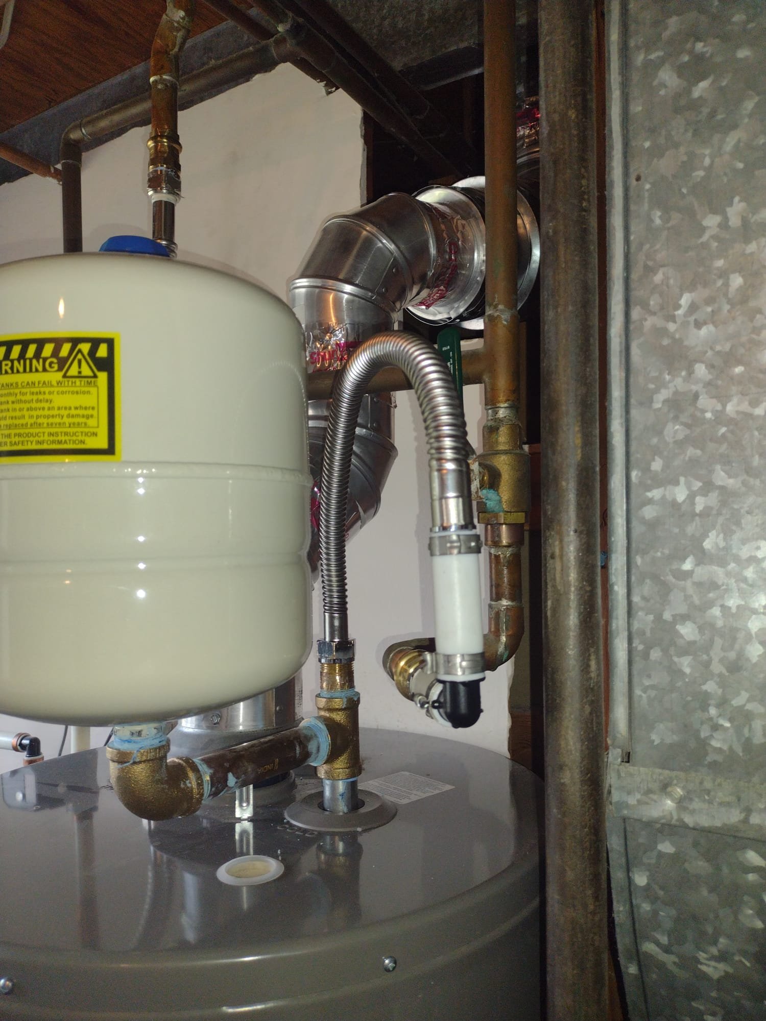 Close-up of a water heater being inspected, highlighting the importance of regular maintenance. Find local water heater services and explore tankless water heater installation costs near you for efficient home heating solutions.