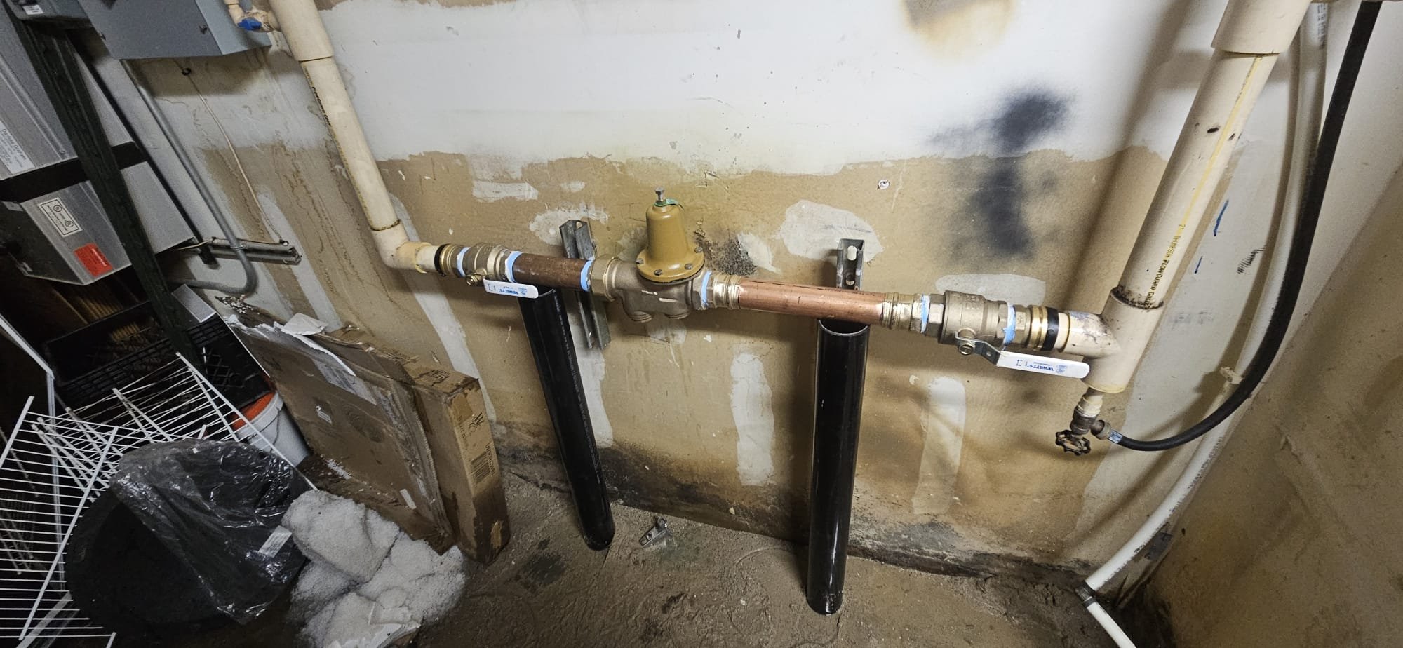 A plumber repairs an outdoor water tap, highlighting the importance of quick plumbing services to prevent water damage and the need for 24-hour hot water solutions and commercial building water damage repair for comprehensive property maintenance.