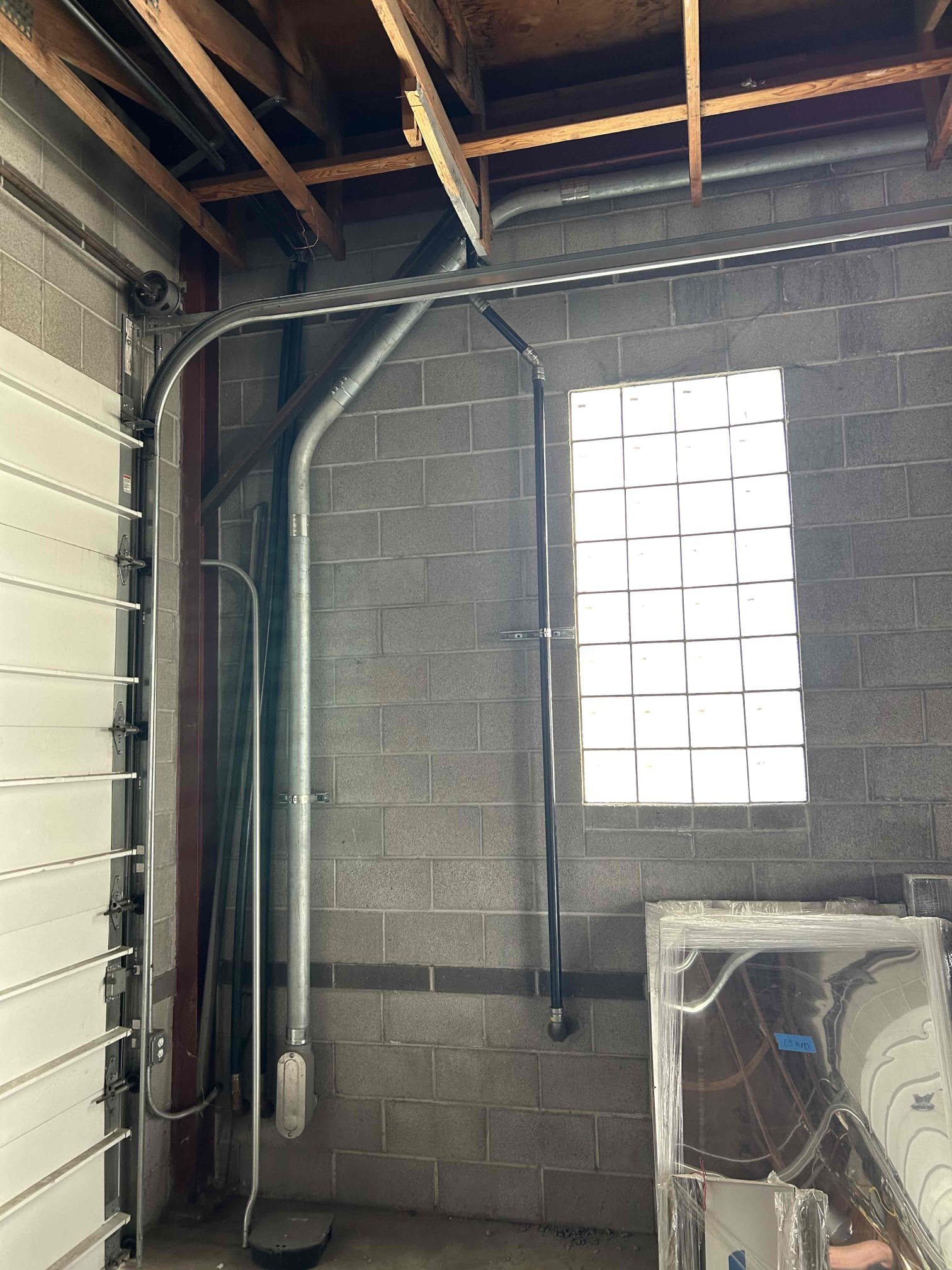 Image of a plumber working on a kitchen sink, highlighting plumbing services related to leaky tub faucets and faucet installation inspections for comprehensive home maintenance.
