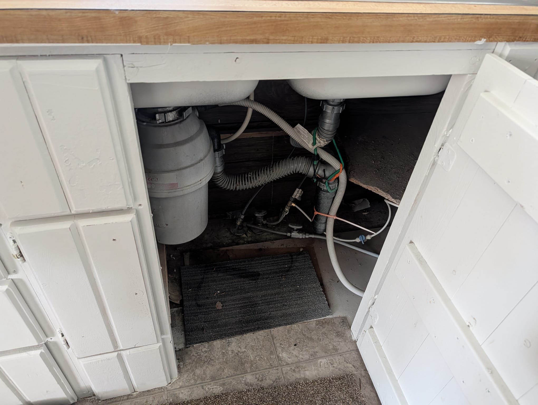 Close-up of a stainless steel Pfister Pasadena faucet with water running in a kitchen sink. The faucet's spout, handle, and other parts are clearly visible, showcasing its modern design and functionality.
