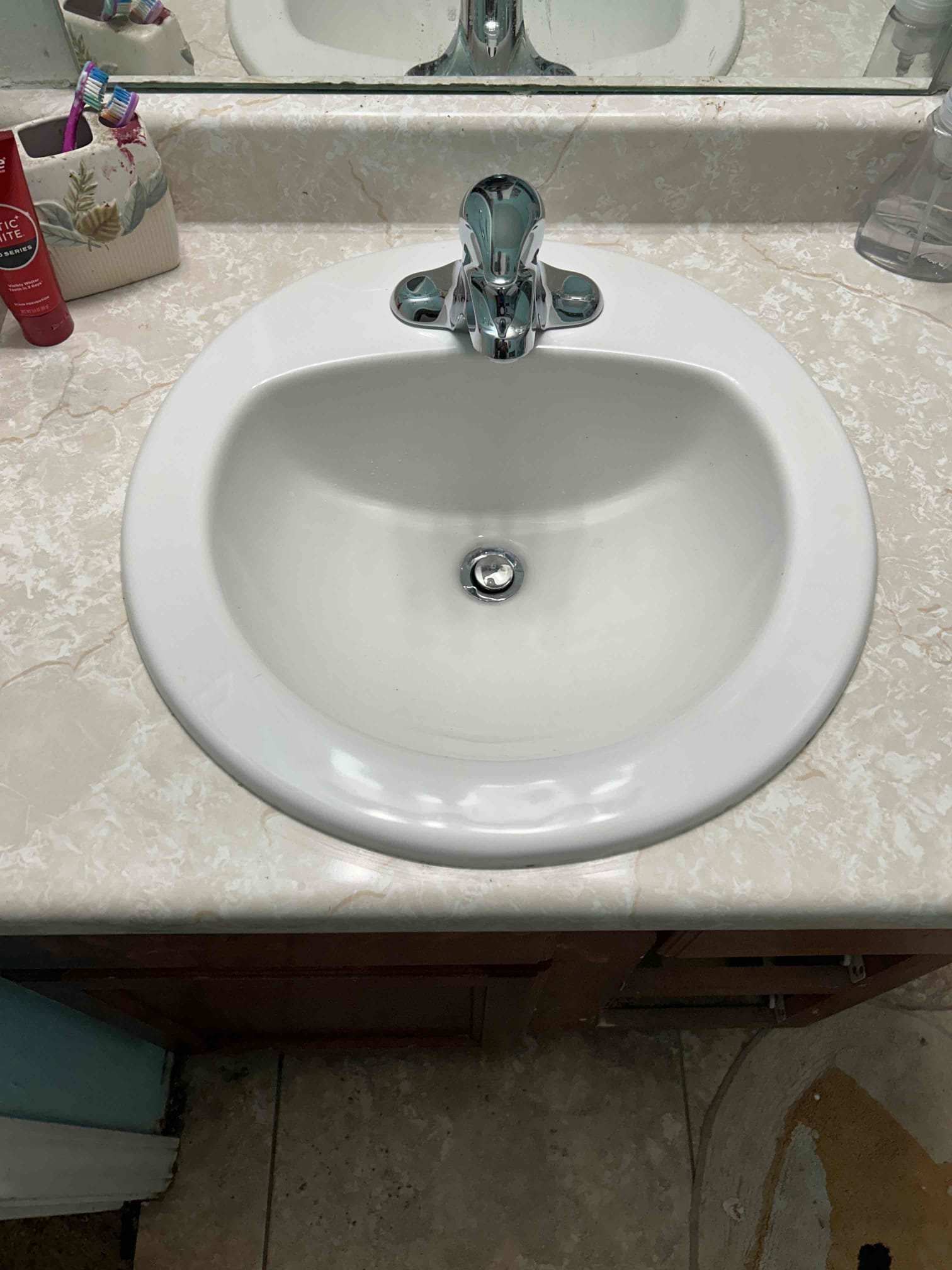 Close-up of a mainline kitchen faucet, highlighting a common plumbing issue: a leak at the base. This image emphasizes the importance of regular faucet maintenance to prevent water damage and costly repairs. Essential for homeowners and those interested in DIY plumbing solutions.