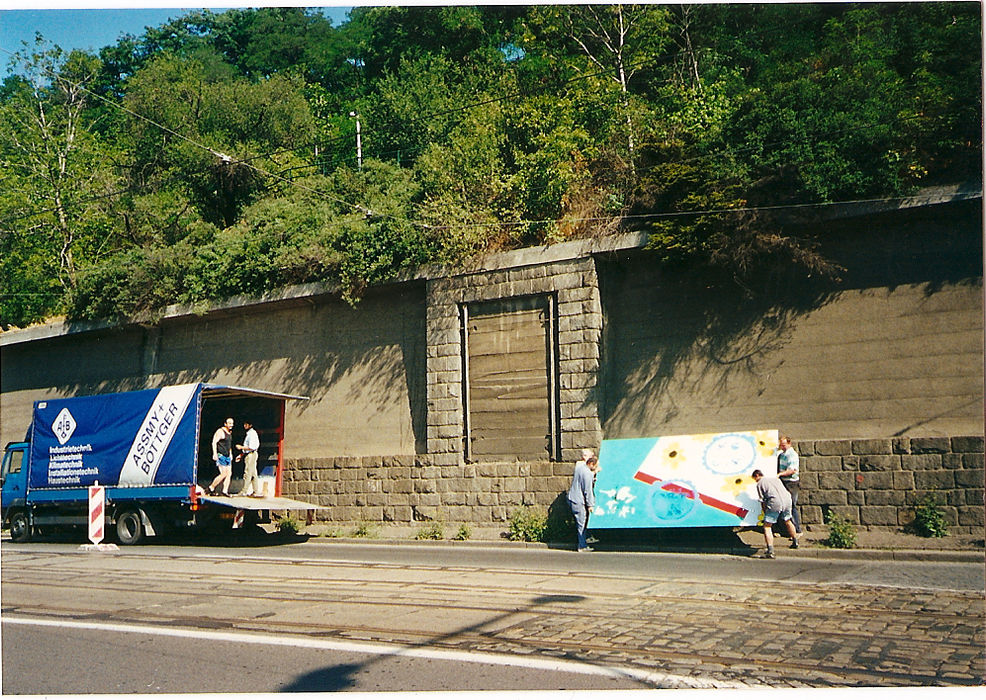 people installing men installing flower power large abstract paintings by Barbara Benish for ArtWall in Prague
