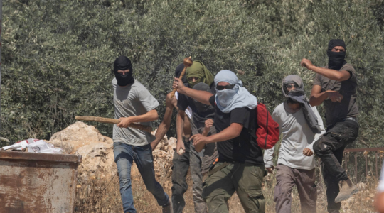 מתנחלים רעולי פנים במהלך תקיפה