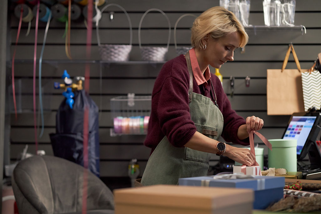 caucasian-young-adult-woman-wrapping-gift-box-with-ribbon-flower-shop.jpg
