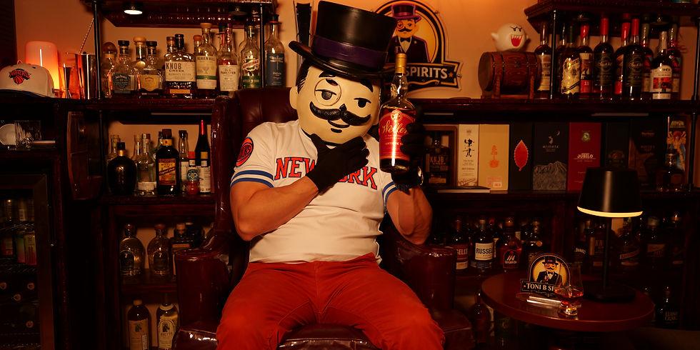 Toni B reviewing bourbon and tequila in his home bar