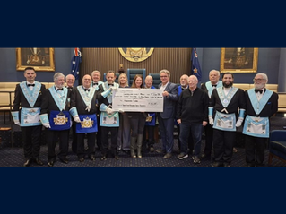 Members of several Victorian Masonic Lodges stand alongside representatives from Yarrabah Specialist Development School and the Freemasons Foundation Victoria during a cheque presentation ceremony, holding a ceremonial cheque for $48,300 to support assistive communication technology for students.