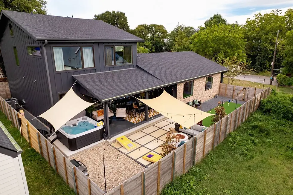 East Austin farmhouse rental exterior with modern architecture, backyard patio, hot tub and entertainment space