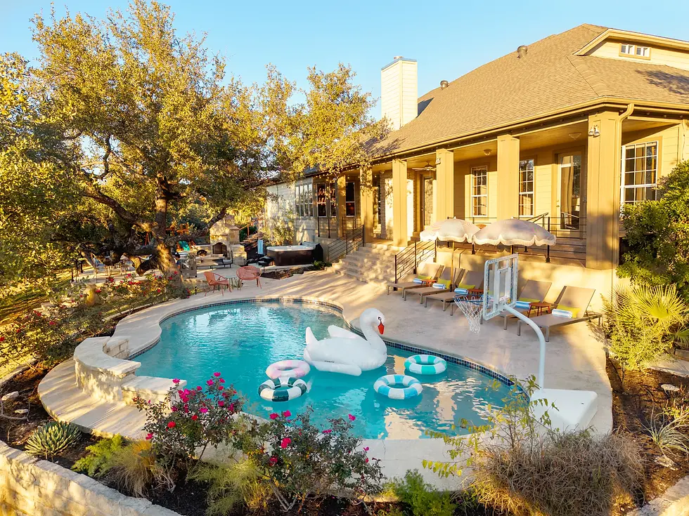 Luxury backyard pool oasis with lounge chairs and patio at Dripping Springs vacation rental