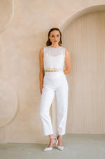 Frau in weißem Zweiteiler posiert, lächelt. lieben.tanzen.lachen.