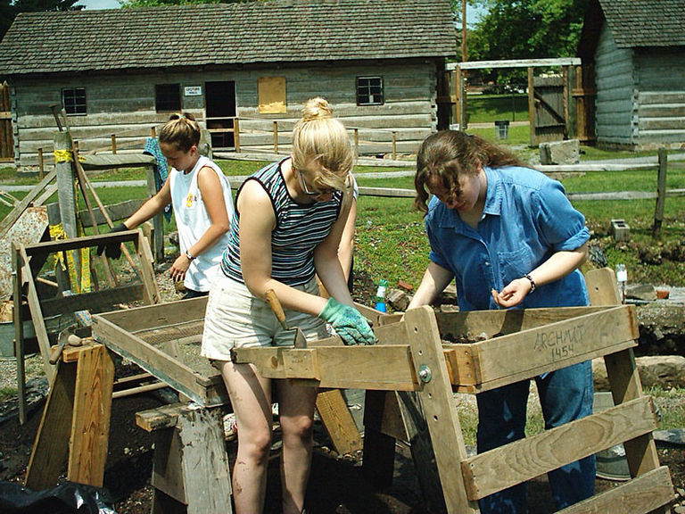 Three women using sifting boxes