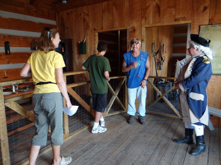 Frontier reenactor with a group of three other people